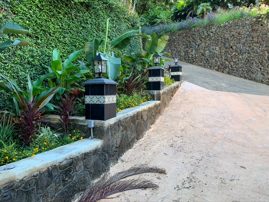 Project Gallery Natural stone wall with pathway lantern lighting along a curved driveway