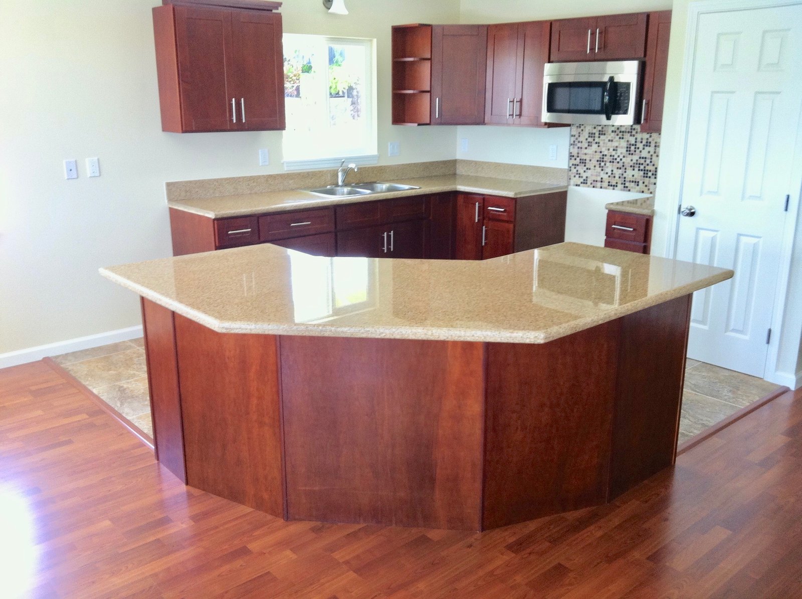 Project Gallery Angled granite island with multi-point seating in a U-shaped kitchen