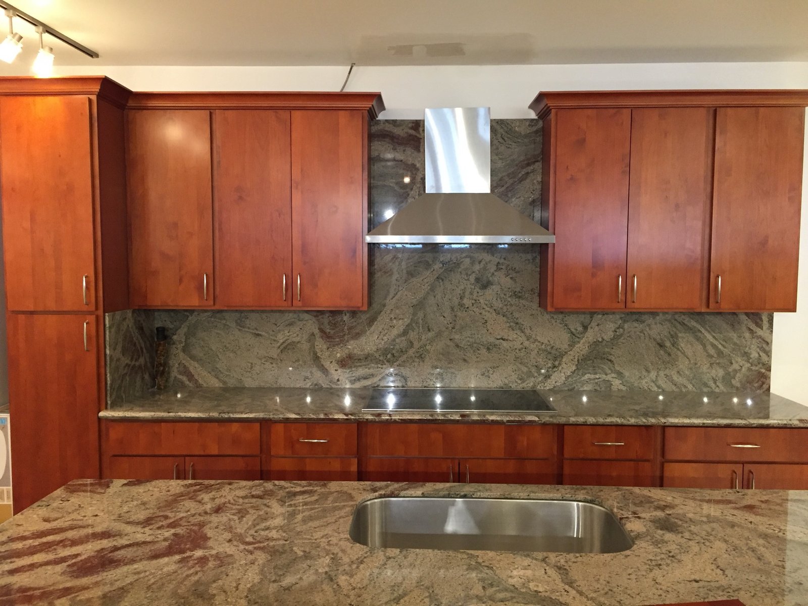 Project Gallery Full-slab granite backsplash with stainless range hood installation