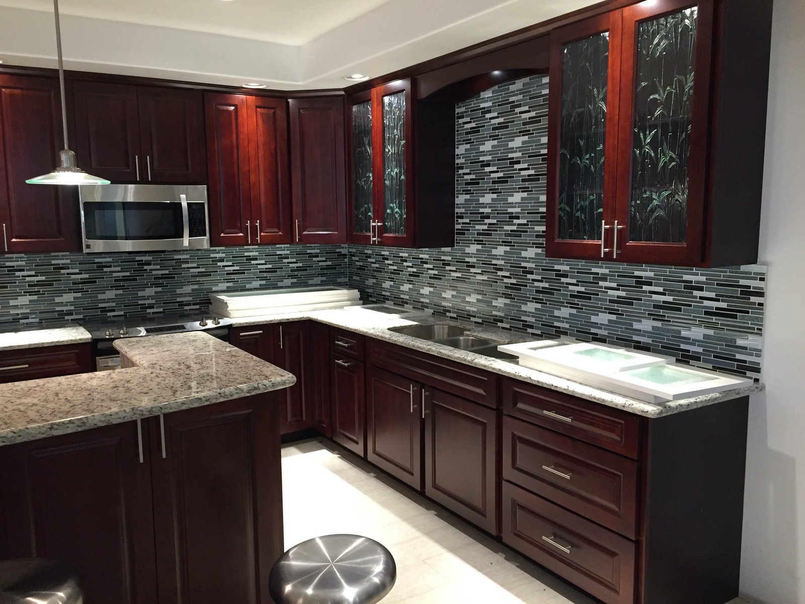 Project Gallery Mosaic tile backsplash with bamboo glass-inset cabinetry and granite counters