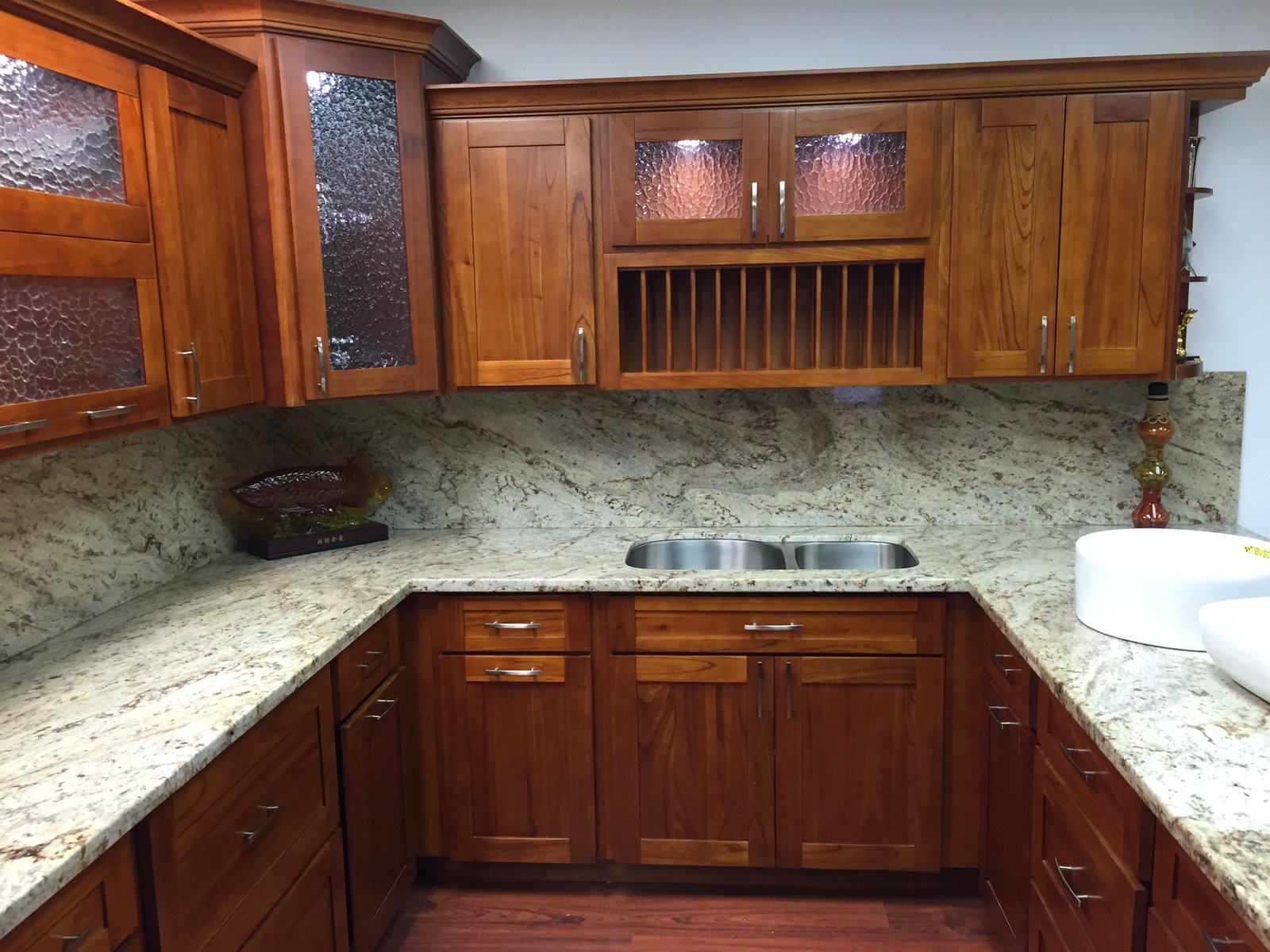 Project Gallery Textured glass cabinet inserts with a built-in plate rack over granite counters