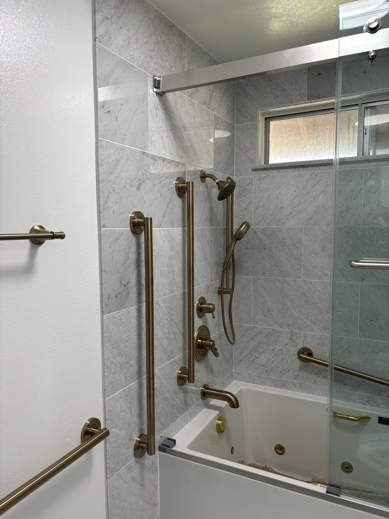 Project Gallery Marble tile tub surround with brushed brass grab bars and shower system