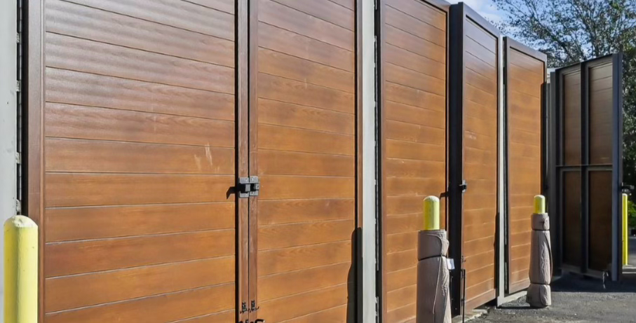 Project Gallery Row of woodgrain aluminum bay doors along an industrial storage yard