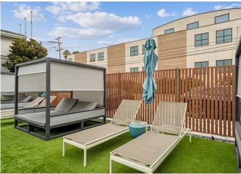 Powder-coated aluminum batten privacy screen enclosing a resort pool deck and cabana