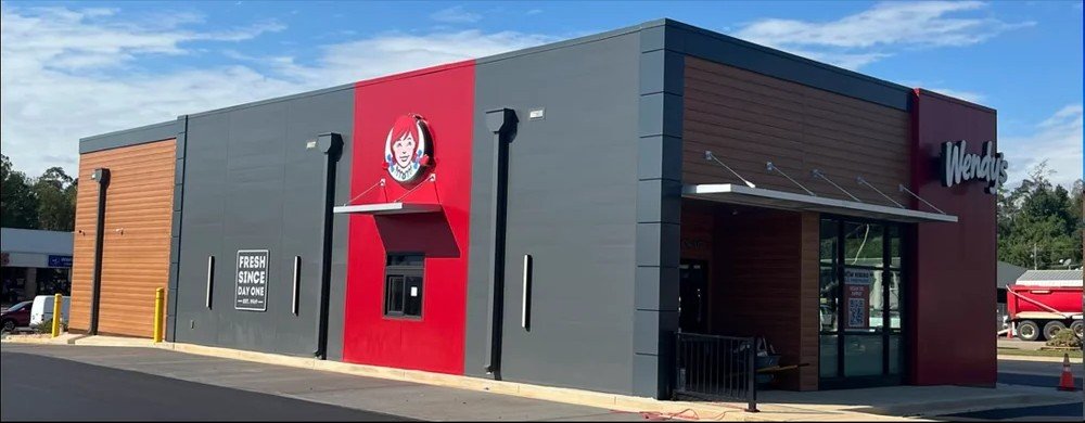 Project Gallery Wendy's quick-service storefront with dark metal panel and wood-look cladding